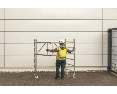 Byggnadsarbetare skjuter en rullställning.