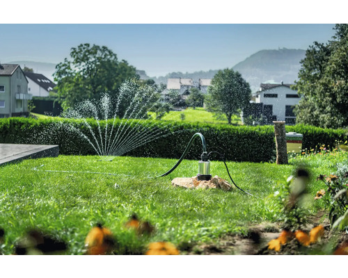 Trädgårdslandskap med grässprinkler och dränkbar pump för trädgårdsbevattning