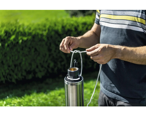 Man fäster ett rep på en dränkbar tryckpump