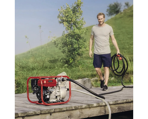 Bensinvattenpump på trägång med man som håller en slang