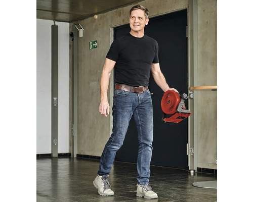 Man bär en sladdlös fläkt i en hall.