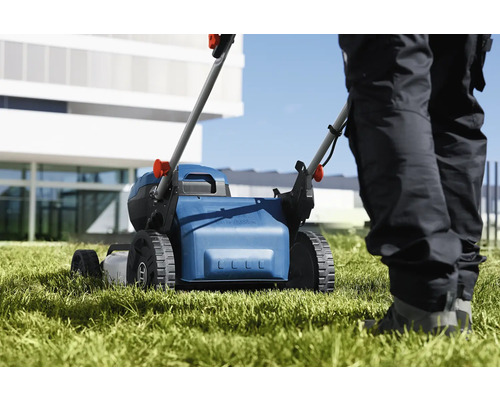 Gräsklippare i bruk på en gräsmatta.