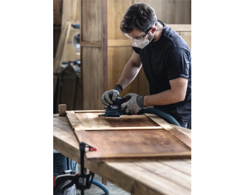 Man slipar trädörr med en planslipmaskin