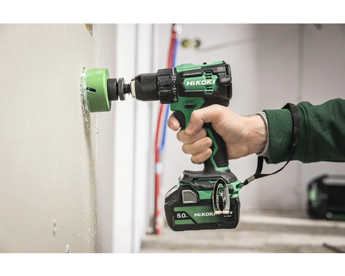 En borrmaskin borrar ett hål i en vägg med en hålsåg.