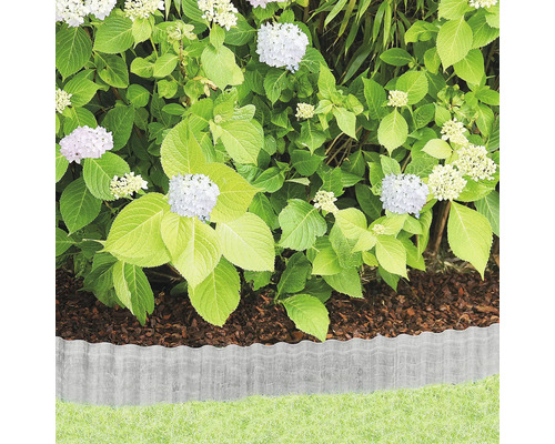 Trädgårdsscen med gräsmatta, rabatt med täckbark, hortensior och gräsmattekant