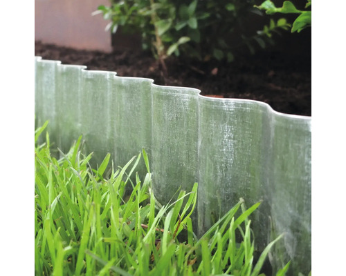 Trädgårdslandskap med gräskant av plast