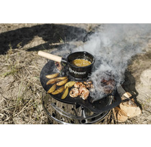 En Petromax Atago-grill med grillplatta, mat på den och en Petromax-kastrull