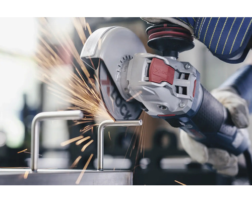 En person skär en metallbit med en vinkelslip, vilket skapar gnistor.