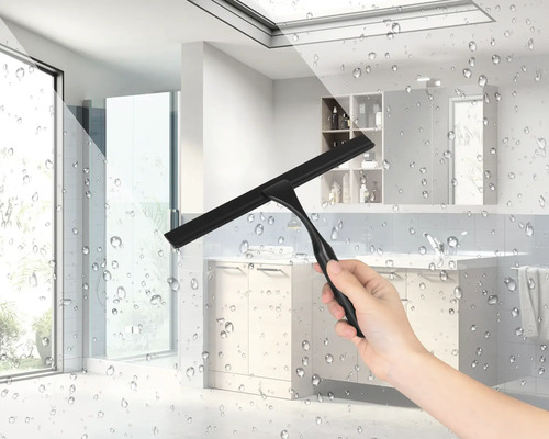 En hand håller en svart duschskrapa i ett badrum.