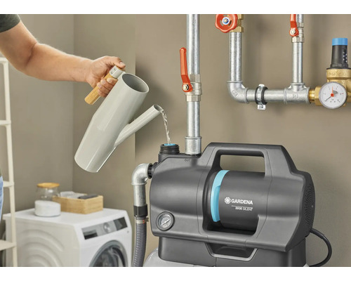 En person fyller en Gardena hydroforpump 3600 Silent med en vattenkanna.