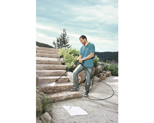 Man rengör trappa av sten med högtryckstvätt