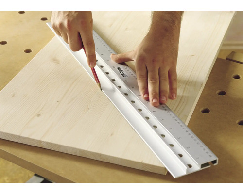 Person som ritar en linje med en penna längs en Wolfcraft linjal på en träplanka