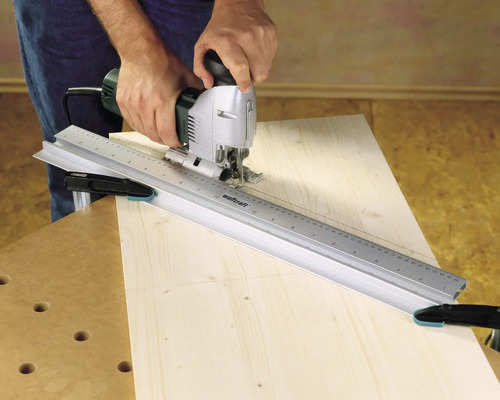 Hantverkare använder sticksåg med styrskena på trä