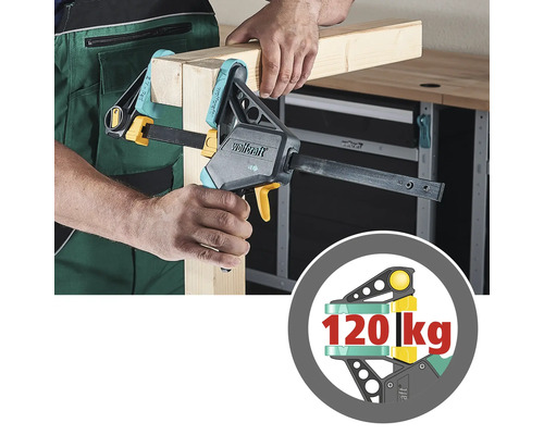 En person fäster träbitar med en enhandsspännare från Wolfcraft. Symbolen visar en lastkapacitet på 120 kg.