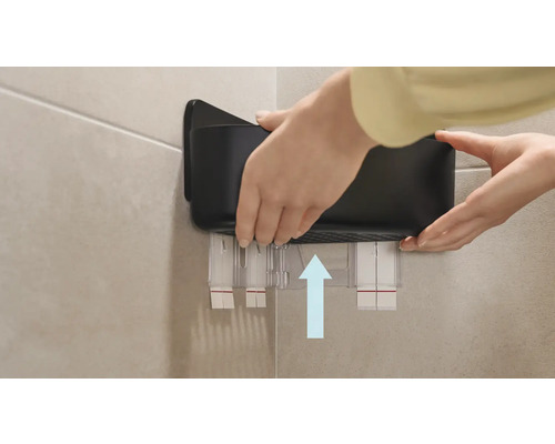 Person monterar badrumsförvaringslåda på väggen