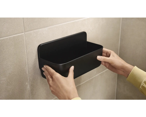 Montering av en svart duschhylla på väggen