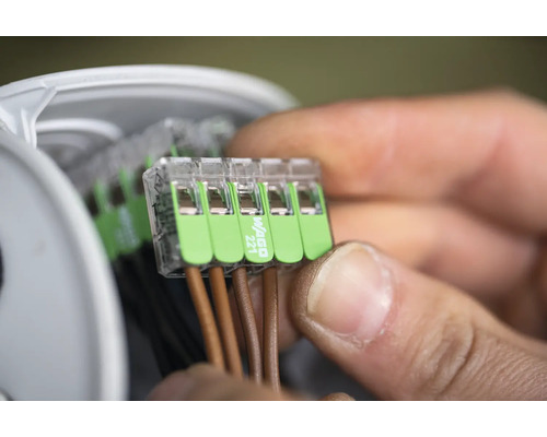 Närbild av en man som ansluter elektriska ledningar med en Wago 221-anslutning