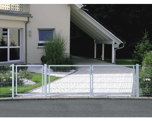 Infartsport av metall framför bostadshus med carport