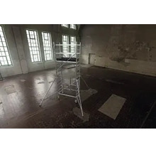 Ställning i ett tomt rum med stora fönster för byggnadsarbete.