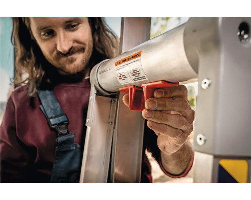 Man som använder förlängningsmekanismen på en stege