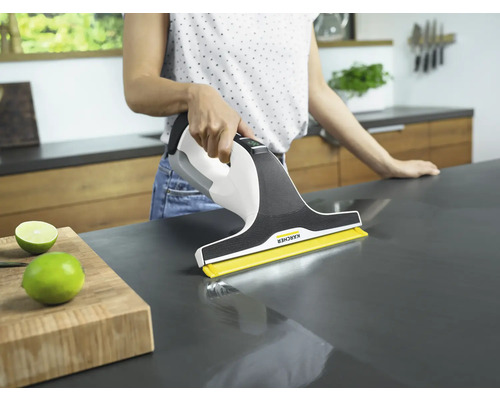 Kvinna rengör bänkskiva med en Kärcher fönstertvätt