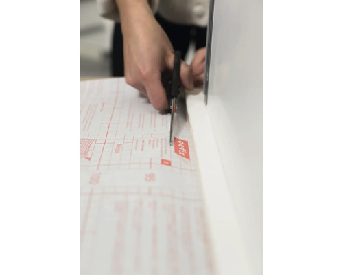 En person skär dekorfolie med en sax.