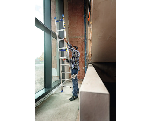 Hantverkare placerar en multifunktionell stege i en byggnad.