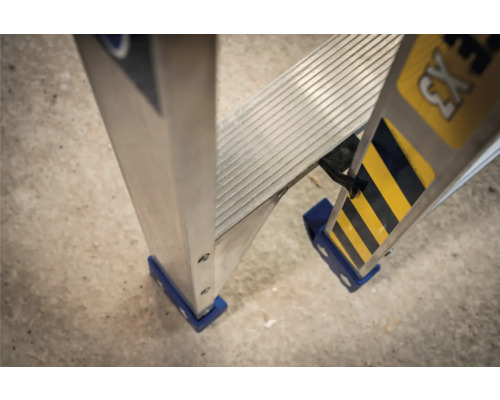Detaljvy av en aluminiumstege med räfflade steg och blå säkerhetsfötter