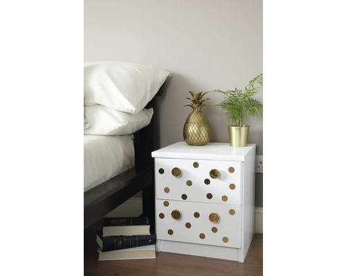 Dekorativ sovrumsmiljö med sängbord, krukväxt och ananasdekoration