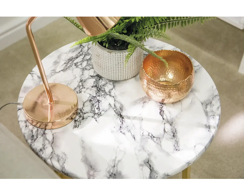 Runt sidobord med marmorlook, en lampa, en växt och en skål