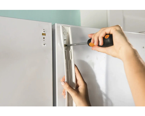 Montering av en skåpdörr med en skruvmejsel