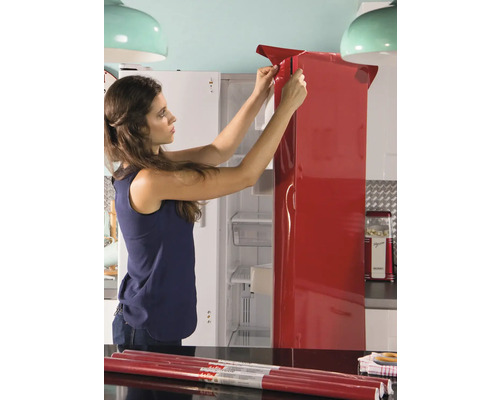 Kvinna applicerar folie på kylskåp