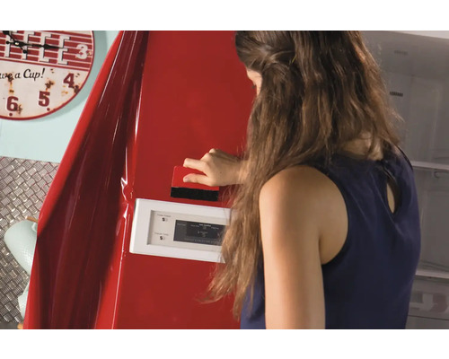 Kvinna applicerar dekorativ film på ett kylskåp med en skrapa