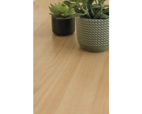 Dekorativa konstgjorda växter i krukor på en träyta.