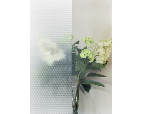 Strukturglas med triangulärt mönster bredvid en vas med blommor