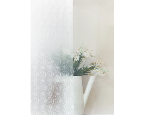 Dekorativ film med abstrakt mönster bredvid en kanna med blommor