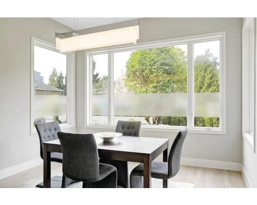 Matsal med bord, stolar och fönsterfilm för ökad integritet