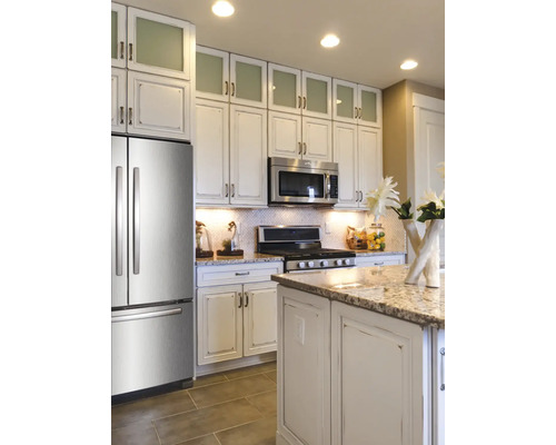 Ljust kök med kylskåp, mikrovågsugn och spishäll i rostfritt stål, samt köksö och överskåp