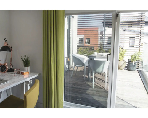 Ljust rum med skrivbord, stol och gardin, utsikt över en terrass med bord och stolar