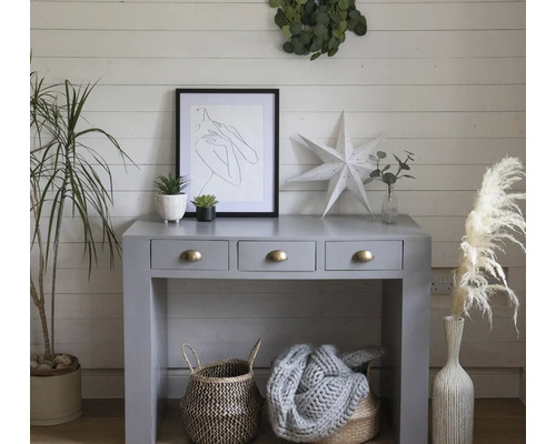 Dekorativt bord med tre lådor, korgar och växter för en stilfull rumsmiljö.