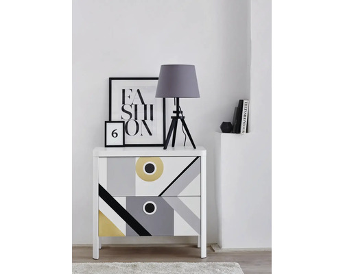 Byrå med geometriskt mönster, bordslampa och dekorativa element