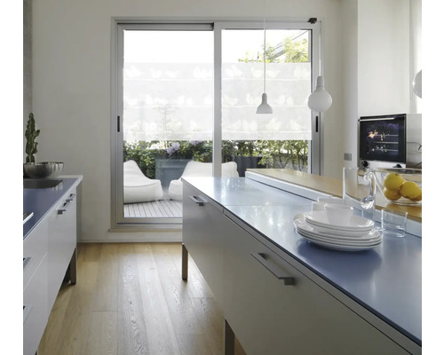 Ljust kök med köksö, porslin och utsikt över terrassen med sittsäckar