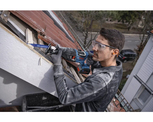 Man arbetar med tigersåg på ett tak