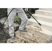 En person rengör stentrappor med en högtryckstvätt.