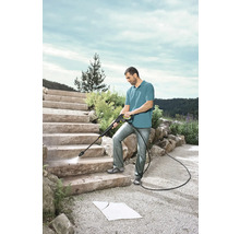 Man rengör stentrappa med en högtryckstvätt utomhus.