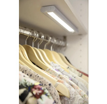 Garderob med LED-belysning och kläder på galgar