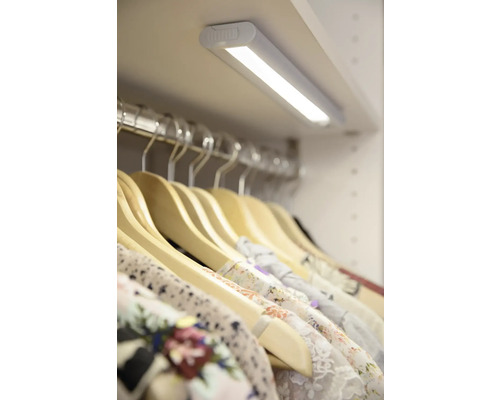 Garderob med LED-belysning och kläder på galgar