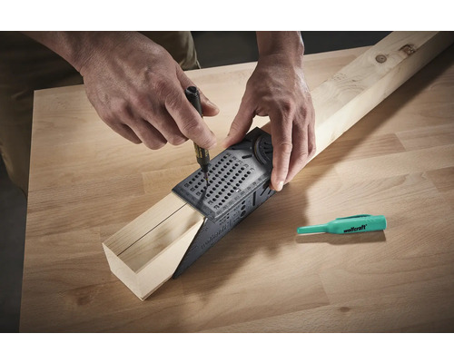 En person använder en vinkelmätare och en penna för att rita en linje på en träbit.