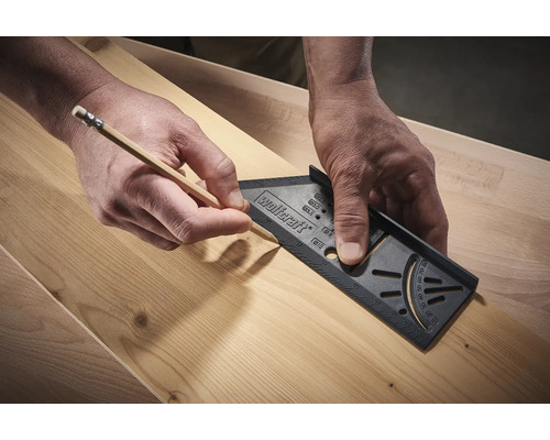 Person ritar med penna och vinkel på trä