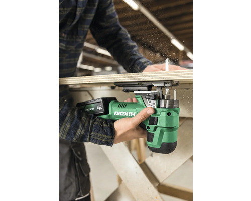 En person använder en sladdlös sticksåg från Hikoki för att såga en träplanka.